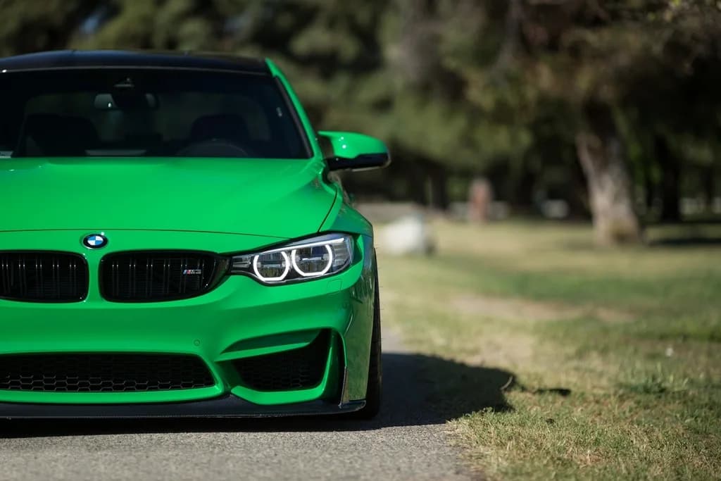 Coupé sportif vert à l'arrêt, vu de trois quarts avant